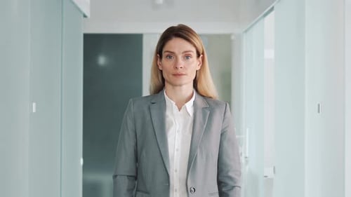Woman Standing in a Bright Office Hallway