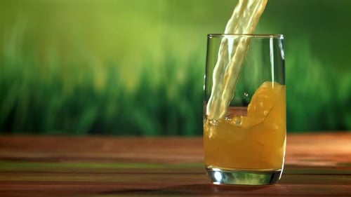 Pouring Refreshing Juice Into a Glass on Table