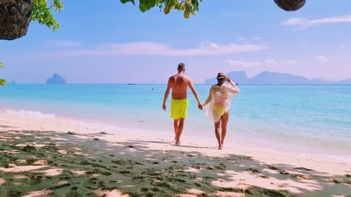 Couple of Men and Women on the Beach of Koh Kradan Island Thailand with a Turqouse Colored Ocean