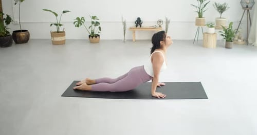 Young Latin Woman Practicing Pilates in a Yoga Studio