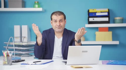 Frustrated Man Working at Desk in Office