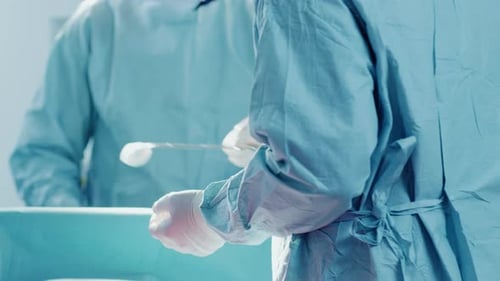 Close-up Shot in the Operating Assistant Hands out Instruments to Surgeon During Operation. Surgery