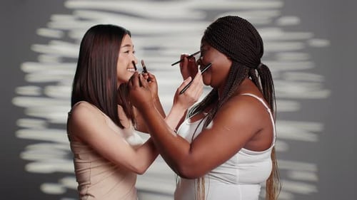Two Young Adults Applying Makeup on Each Other