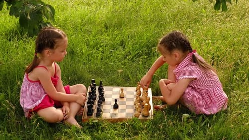 Les filles d'âge préscolaire ont appris à jouer aux échecs et peuvent jouer entre elles.