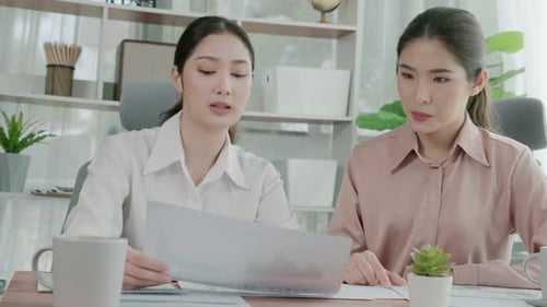 Two Young Enthusiastic Businesswoman Working Together in the Office Workspace