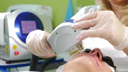 Aesthetician Performing Laser Skin Treatment on Woman