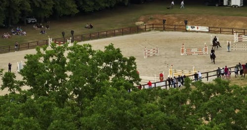 Wettbewerbe von Pferden und Reitern, die auf einem Pferderücken springen und einen Zaun auf Sandy Parkour springen
