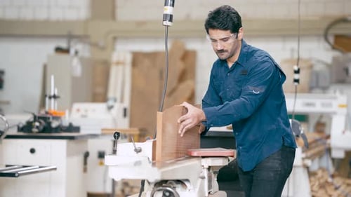 Man Working with Wood in a Workshop