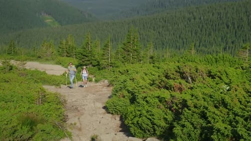 A Man and a Woman are Climbing Up the Mountain Path In a Picturesque Place the Mountains Covered