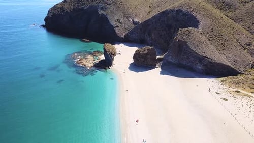 Drone aerial view of seashore, coastline, scenic view of people at unspoiled beach