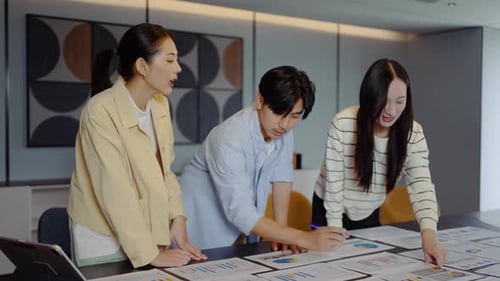 Professional young business team analyzing financial data charts and graphs together in a office