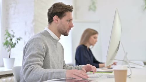 Creative Man Working on Desktop and Coughing in Office