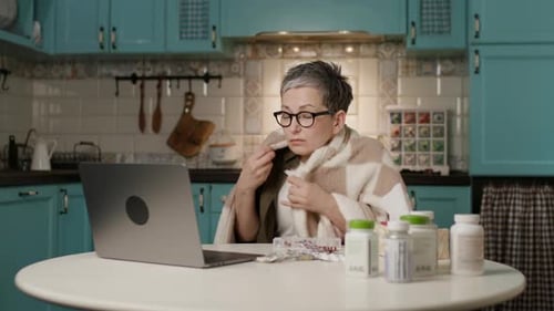 Woman on Laptop Consults Doctor in Kitchen