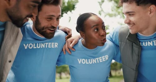Smiling Volunteers Huddle Together in a Park Setting