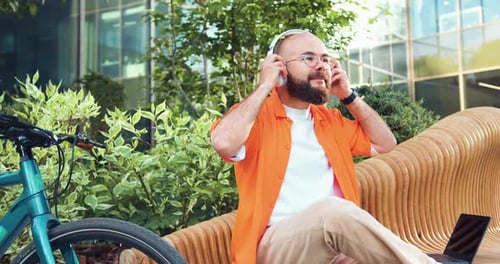 Bearded Man Listening to Headphones in Urban Setting