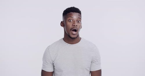 Face, emotion and black man with a surprise, omg and awkward against a white studio background