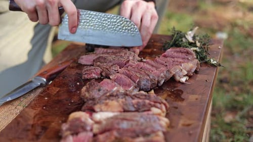 Hands Cut Steak with Knife on Board