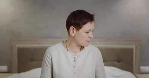 Woman Speaking Candidly in Bedroom Setting