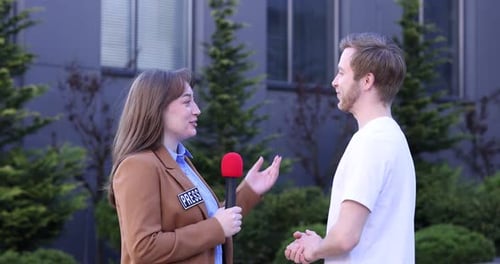 Professioneller Journalist mit Mikrofon interviewt Mann im Freien