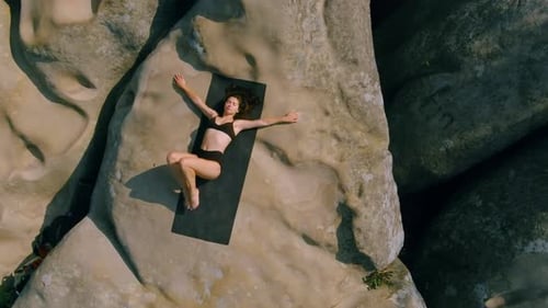 Woman Doing Yoga on Rock Formation Aerial Shot
