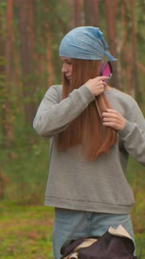 Women Take Relaxing Forest Break with Thermos and Hair Brush