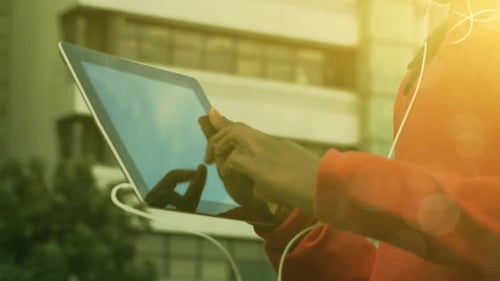 Woman uses tablet outside in golden sunlight
