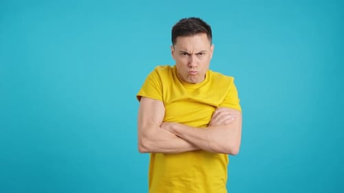 Man with Angry Expression Crosses Arms