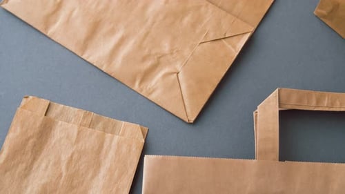 Recycling Reuse and Ecology Concept - Disposable Paper Bags on Grey Background Background