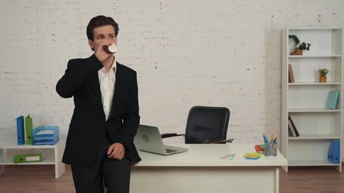 Young Adult Drinking Coffee in Modern Office