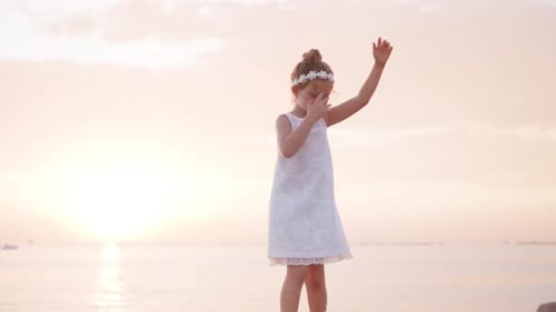 Child Dances on Beach at Sunset