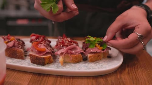 Adult Garnishing Open Faced Sandwiches in Restaurant