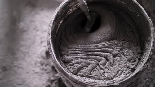 Mixing Grey Cement in a Bucket Close Up