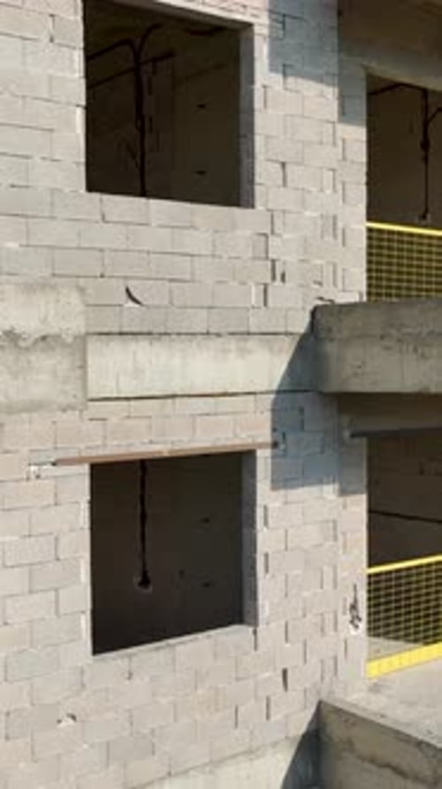 Vertical Footage Worker Adjusting Panel on Formwork Structure with Tools and Equipment Nearby