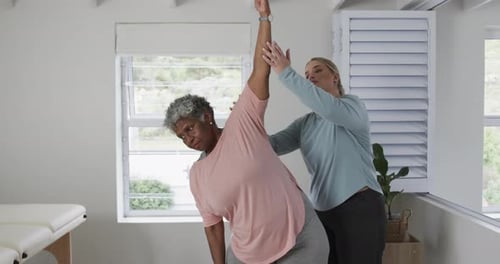 Senior Woman Stretching with Assistance in Clinic