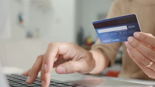 Hands Typing on Laptop with Credit Card