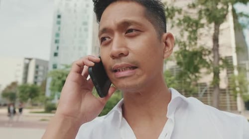 Young Adult Man Talking on Mobile Phone in City