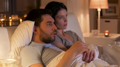 Couple Watching Movie, Cuddling in Bed at Night