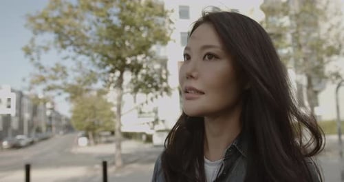 Beautiful Asian woman looking into camera, Portrait Korean female in City