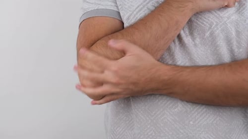 Man Holding His Elbow in Pain Close Up