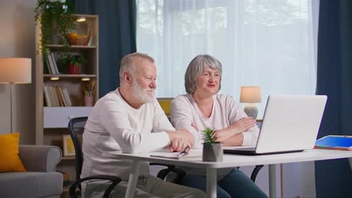 Senior Couple Using Laptop for Video Call at Home