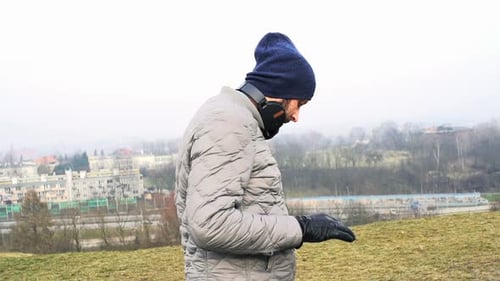 Sporty Man Setting Music on Smartphone in City Park Active