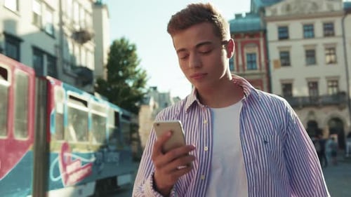 Smiling Young Happy Man Walk on Street Use Phone Look Around Sunlight Cute Work Mobile Gadget