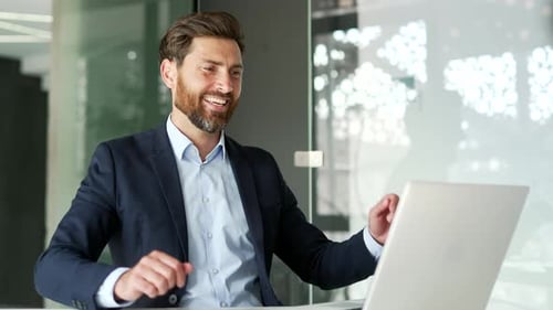 Excited Man Working on Laptop at Modern Office