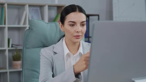 Businesswoman Looks at the Computer Screen with Fear of Terrible News While Sitting at Office