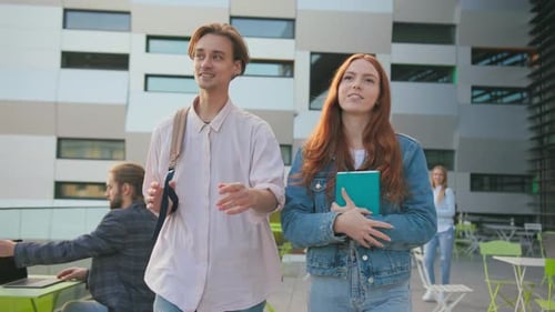 Caucasian Couple of Young University Classmates Wearing Backpacks Walking and Talking Outside Modern