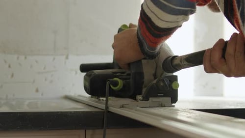 Worker Cutting Kitchen Countertop with Circular Saw