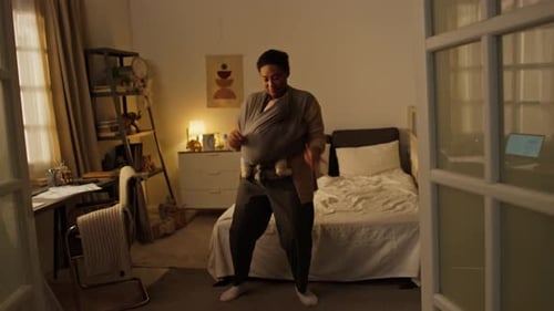 Woman Dancing with Baby in Carrier at Home