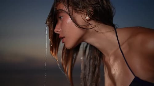 An Elegant Woman Posing Gracefully By the Ocean at Sunset
