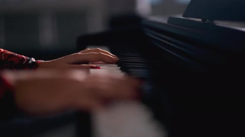 Close view female's fingers play piano.