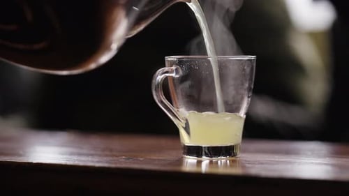 Pouring Hot Lemon Tea. steam rising from the glass. 4K - Close-Up